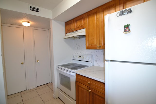 kitchen with white appliances, tasteful backsplash, light tile patterned flooring, and light stone counters