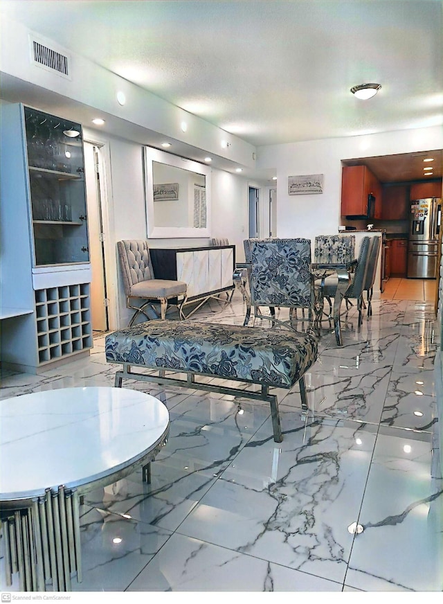 living area featuring marble finish floor and visible vents