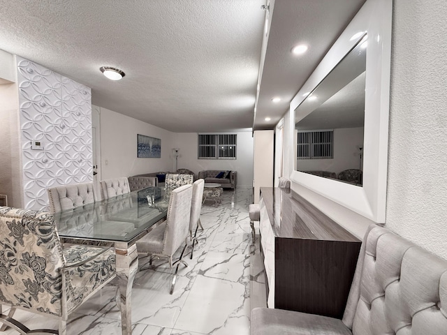 dining area with marble finish floor and a textured ceiling