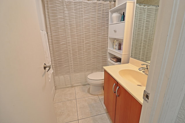 full bathroom with toilet, a tile shower, tile patterned flooring, and vanity