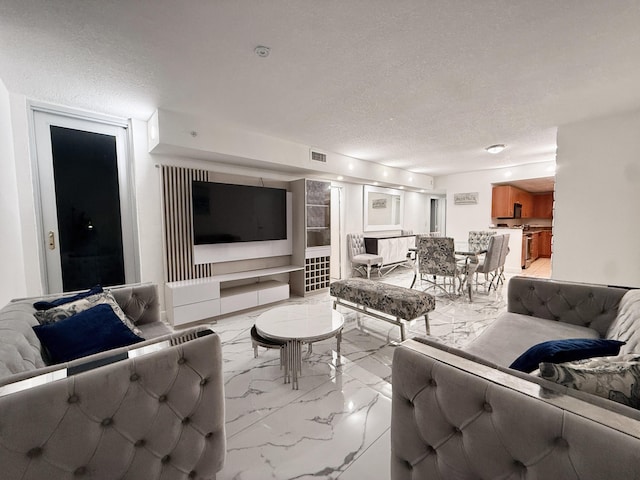 living room featuring a textured ceiling, visible vents, and marble finish floor