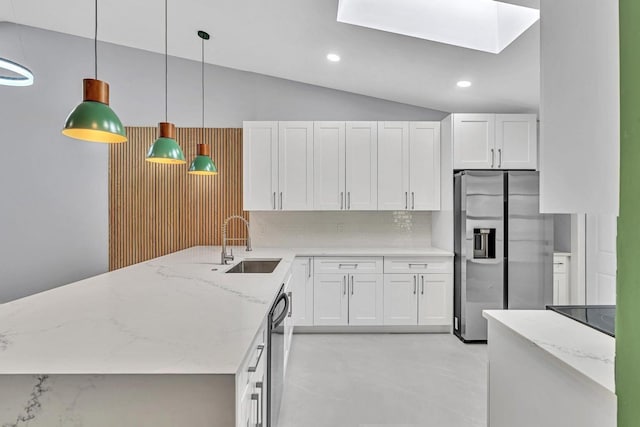 kitchen with sink, white cabinetry, appliances with stainless steel finishes, pendant lighting, and light stone countertops