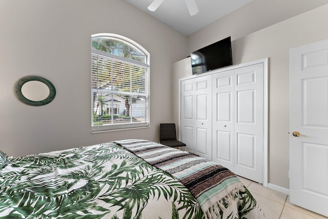 bedroom featuring vaulted ceiling, light tile patterned floors, ceiling fan, and a closet