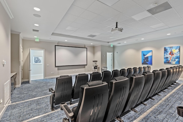 cinema room featuring ornamental molding, a tray ceiling, and carpet floors