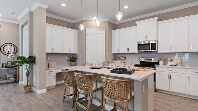 kitchen featuring white cabinetry, appliances with stainless steel finishes, and decorative light fixtures