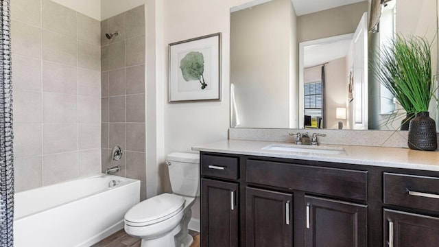 full bathroom featuring vanity, toilet, tiled shower / bath combo, and hardwood / wood-style floors