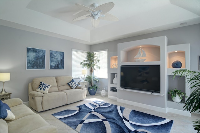 living room with ceiling fan and a raised ceiling