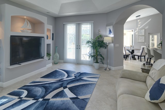 tiled living room featuring french doors and a chandelier