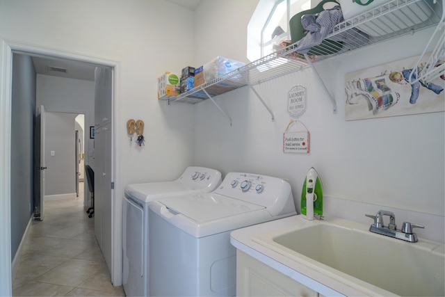 clothes washing area featuring light tile patterned flooring, independent washer and dryer, and sink