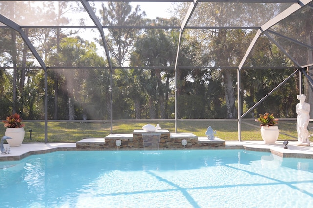 view of pool with pool water feature and glass enclosure