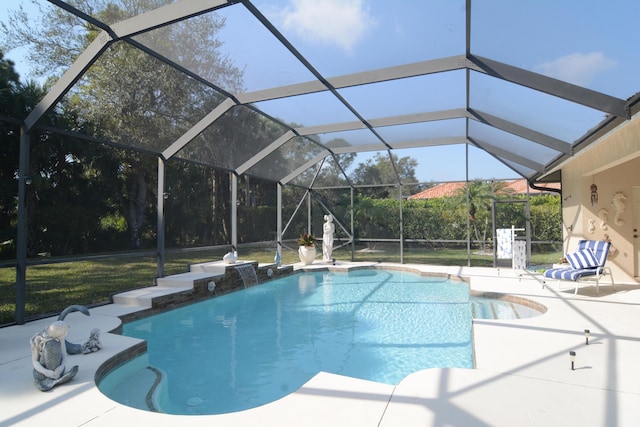 view of pool with a patio area, pool water feature, and glass enclosure