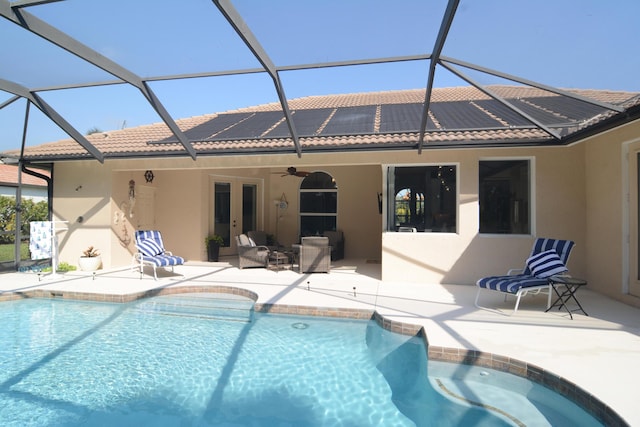 rear view of property with a patio area, ceiling fan, and solar panels