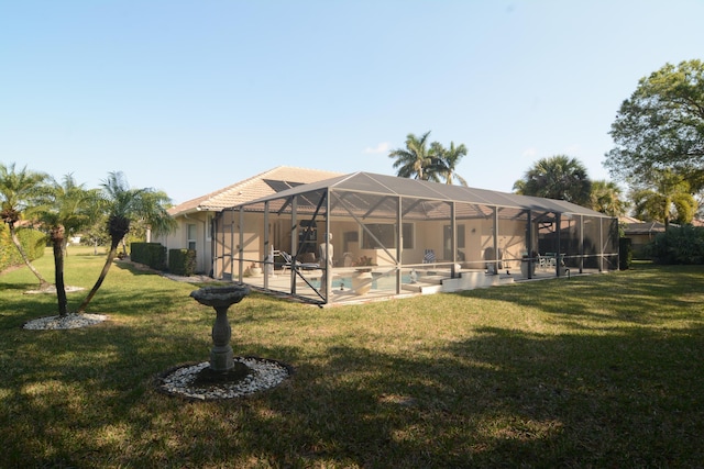 rear view of house with a patio, a lanai, and a lawn