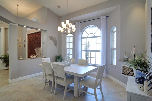 dining space featuring an inviting chandelier, vaulted ceiling, and ornate columns