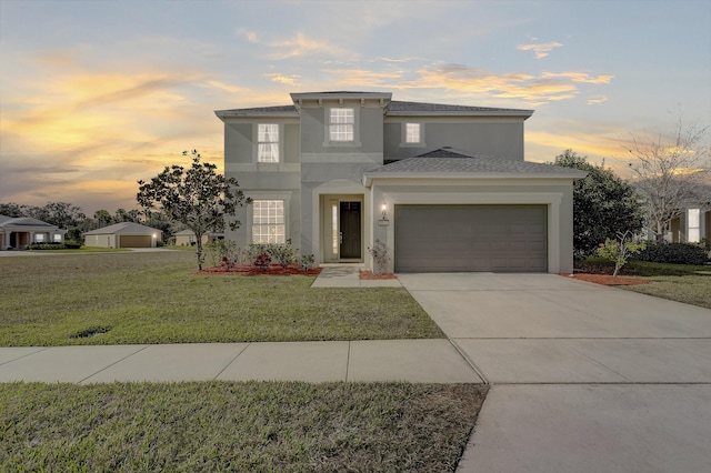 view of front of property featuring a garage and a lawn