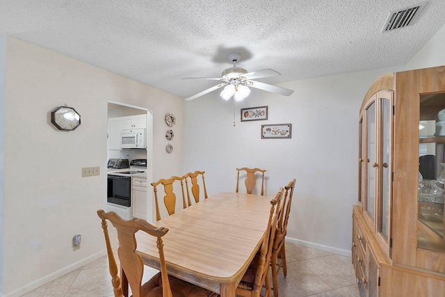 dining area featuring ceiling fan, a textured ceiling, and light tile patterned floors