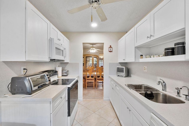 kitchen featuring tasteful backsplash, white cabinetry, sink, and white appliances