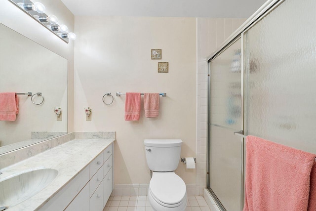 bathroom featuring vanity, toilet, tile patterned floors, and a shower with shower door