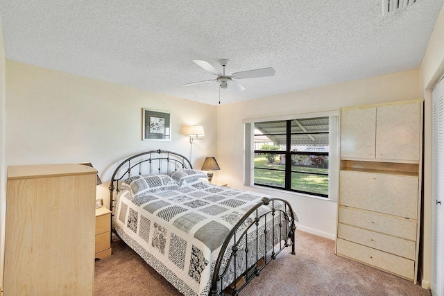 bedroom featuring ceiling fan, carpet floors, and a textured ceiling