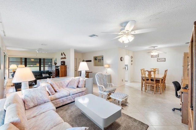 tiled living room featuring ceiling fan and a textured ceiling