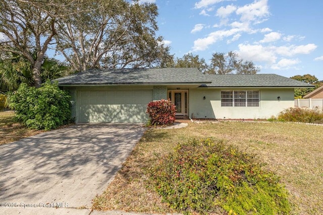 ranch-style house featuring a garage and a front lawn