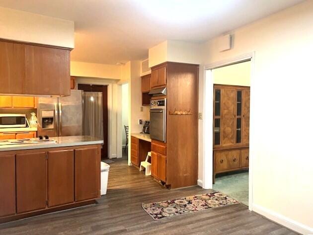 kitchen with stainless steel appliances and dark hardwood / wood-style floors