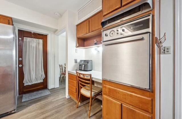 1531 Bacom Point Rd, Pahokee, FL 33476 - kitchen featuring freestanding refrigerator, oven, light wood finished floors, light countertops, and brown cabinets