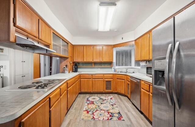 1531 Bacom Point Rd, Pahokee, FL 33476 - kitchen with appliances with stainless steel finishes, light wood-style floors, light countertops, and brown cabinets
