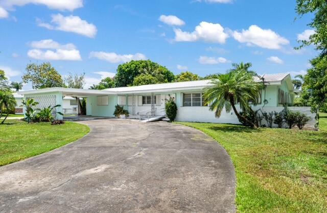 1531 Bacom Point Rd, Pahokee, FL 33476 - ranch-style house featuring driveway, a front yard, and an attached carport