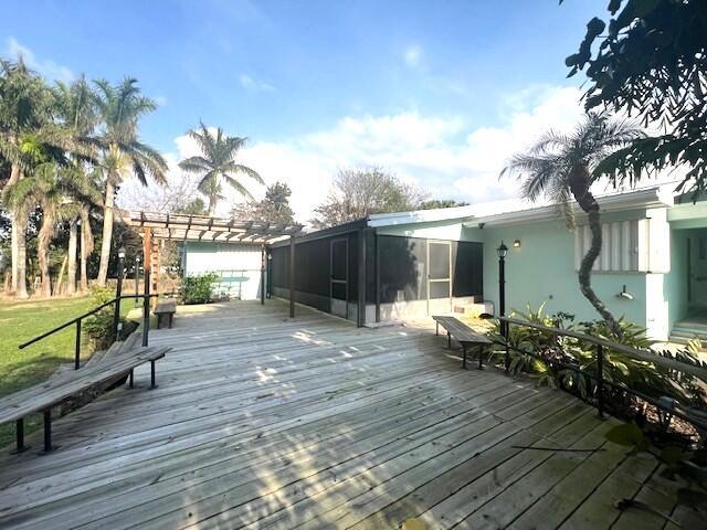 deck featuring a sunroom and a pergola