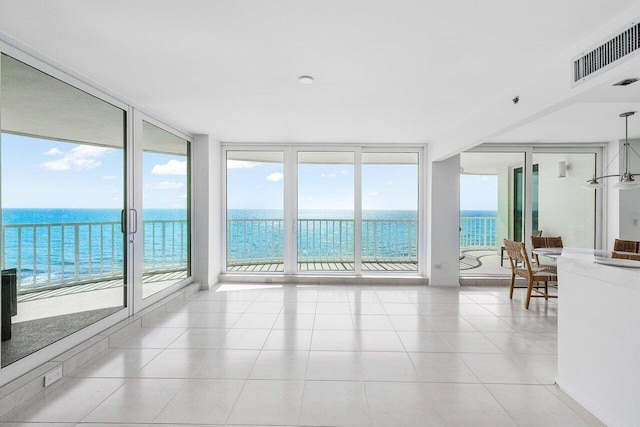 3211 S Ocean Blvd Unit 802, Highland Beach, FL 33487 - sunroom featuring healthy amount of natural light, a wall of windows, a water view, and tile patterned floors