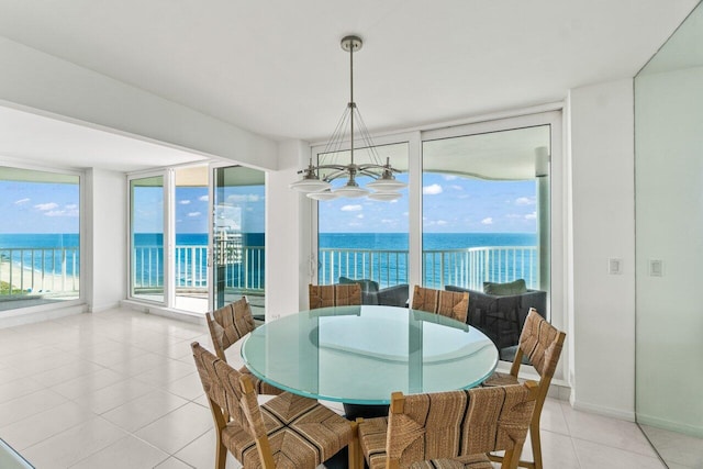 3211 S Ocean Blvd Unit 802, Highland Beach, FL 33487 - dining space featuring a chandelier, light tile patterned flooring, a water view, baseboards, and expansive windows