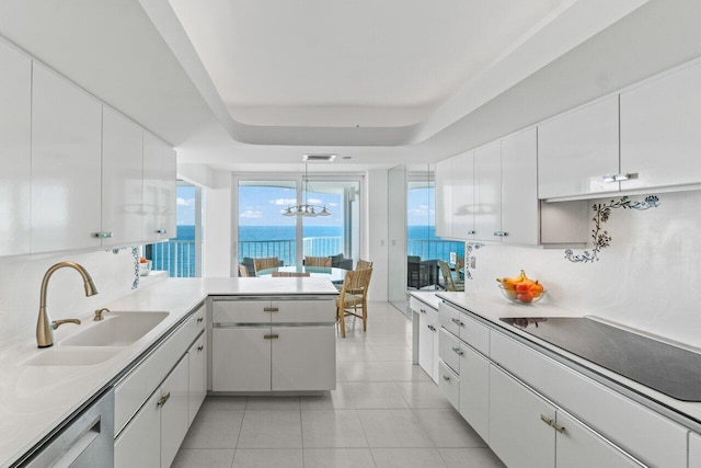 3211 S Ocean Blvd Unit 802, Highland Beach, FL 33487 - kitchen featuring a sink, stainless steel dishwasher, black electric stovetop, a peninsula, and white cabinetry
