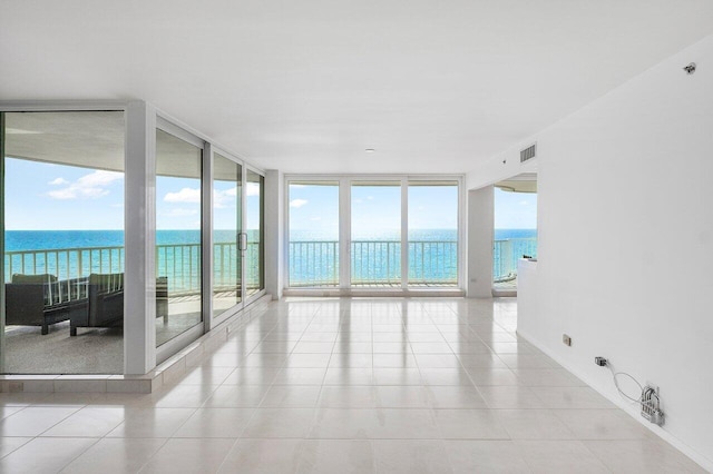 3211 S Ocean Blvd Unit 802, Highland Beach, FL 33487 - unfurnished room with a wall of windows, a water view, and light tile patterned flooring