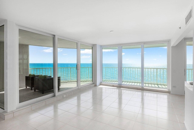 3211 S Ocean Blvd Unit 802, Highland Beach, FL 33487 - unfurnished sunroom featuring a wall of windows, plenty of natural light, a water view, and tile patterned floors