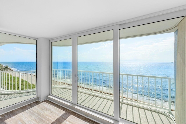 3211 S Ocean Blvd Unit 802, Highland Beach, FL 33487 - unfurnished sunroom featuring wood finished floors and view of water and beach