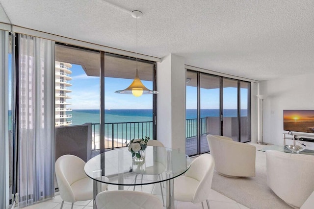 dining space with floor to ceiling windows, a water view, light tile patterned floors, and a textured ceiling