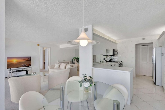 tiled dining area featuring a textured ceiling