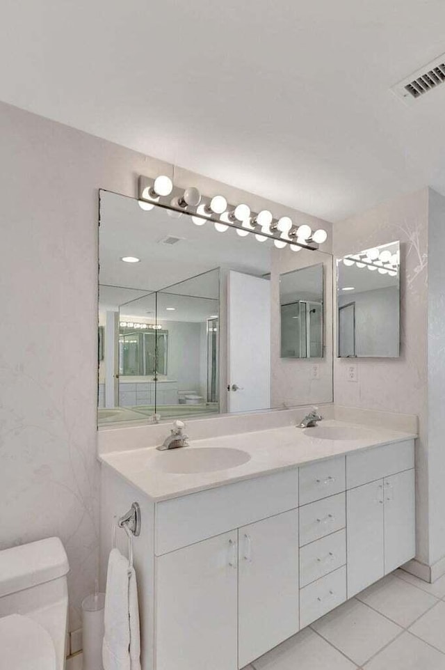 bathroom featuring vanity, tile patterned floors, and toilet