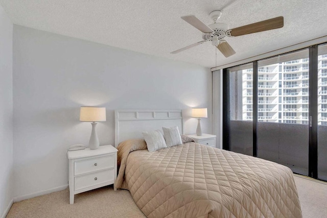 carpeted bedroom featuring ceiling fan and a textured ceiling