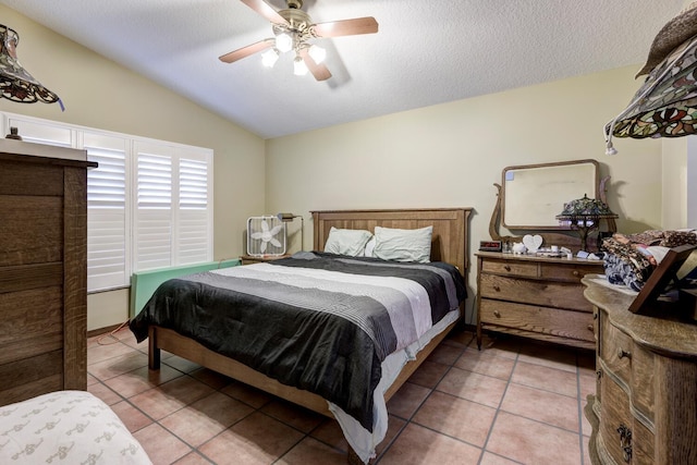 tiled bedroom featuring lofted ceiling, ceiling fan, and a textured ceiling