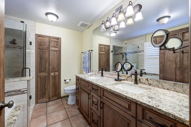 bathroom with tile patterned flooring, vanity, toilet, and walk in shower