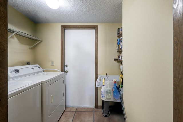 washroom with light tile patterned floors, independent washer and dryer, and a textured ceiling