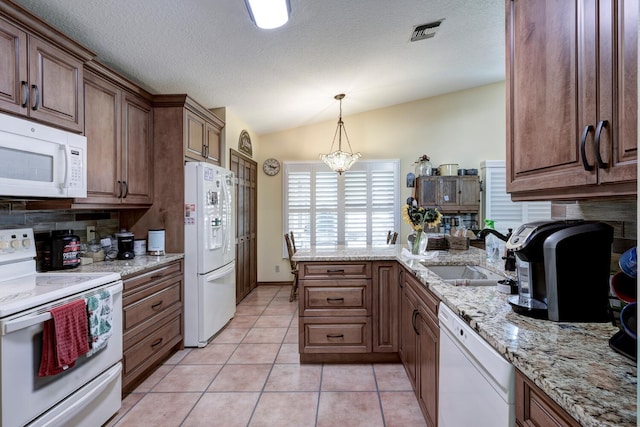 kitchen with pendant lighting, sink, white appliances, lofted ceiling, and light tile patterned floors