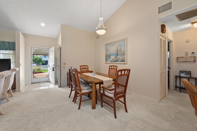 dining area featuring high vaulted ceiling, light colored carpet, visible vents, and baseboards