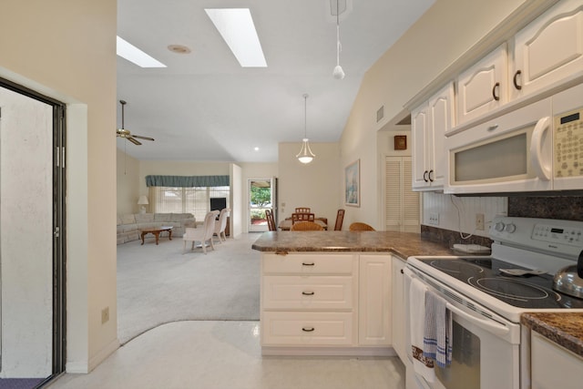 kitchen featuring dark countertops, hanging light fixtures, open floor plan, a peninsula, and white appliances