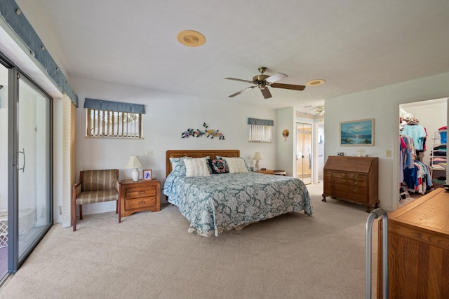 bedroom with ensuite bath, light carpet, a spacious closet, ceiling fan, and a closet