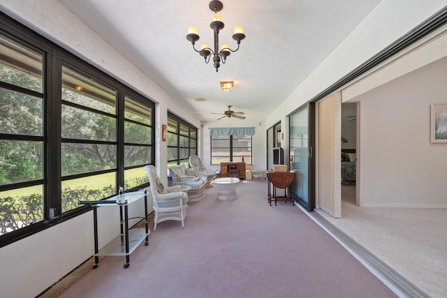 sunroom with ceiling fan with notable chandelier