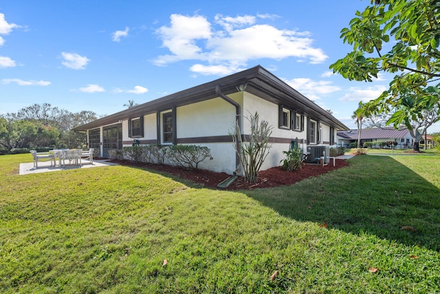 view of property exterior with stucco siding, a patio, a lawn, and central air condition unit