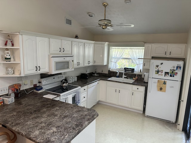 kitchen with white appliances, kitchen peninsula, and white cabinets